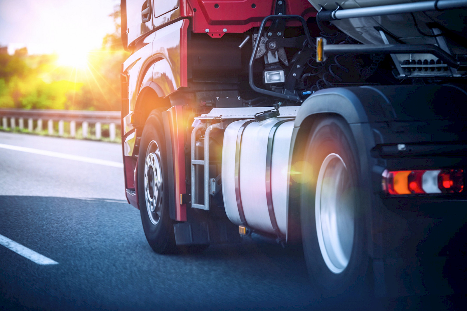 Roter Sattelzug f&auml;hrt bei Sonnenuntergang auf der Autobahn