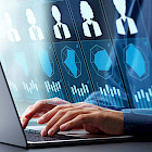 Person am Laptop mit eingeblendeten digitalen Bewerberprofilen und Diagrammen